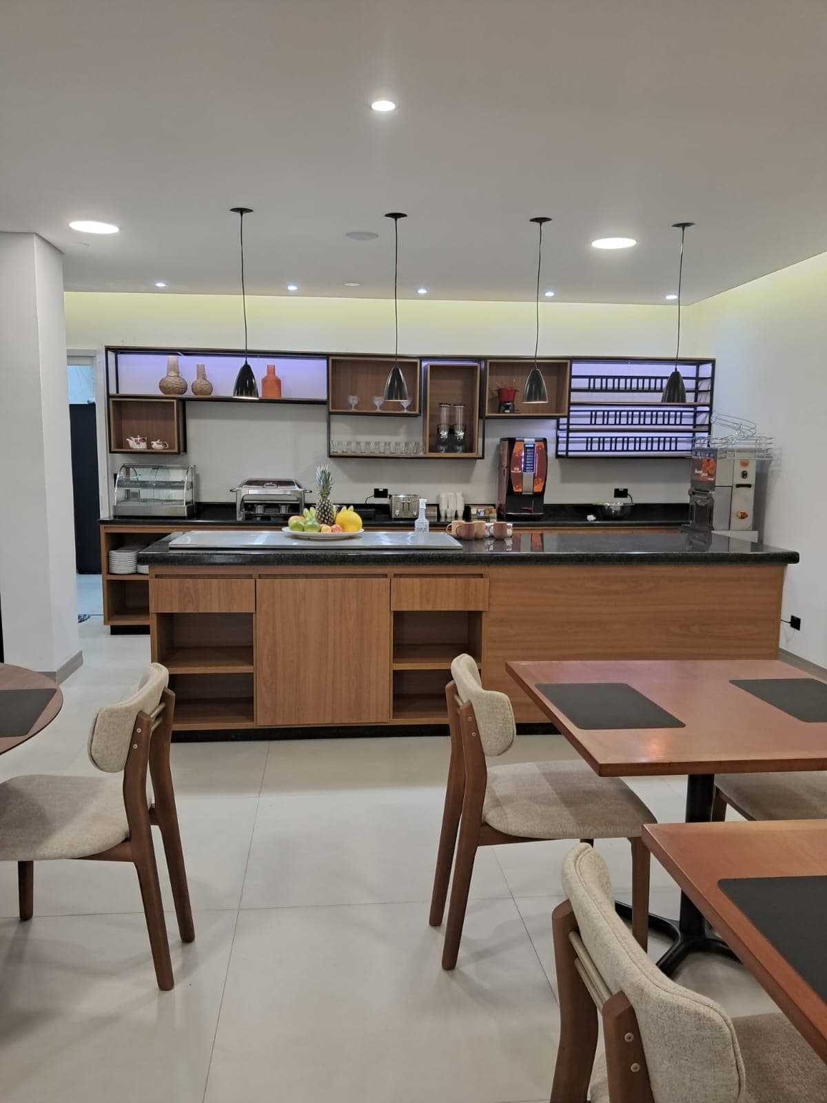 Salão do café da manhã estilo brunch, com frutas frescas e mesas postas