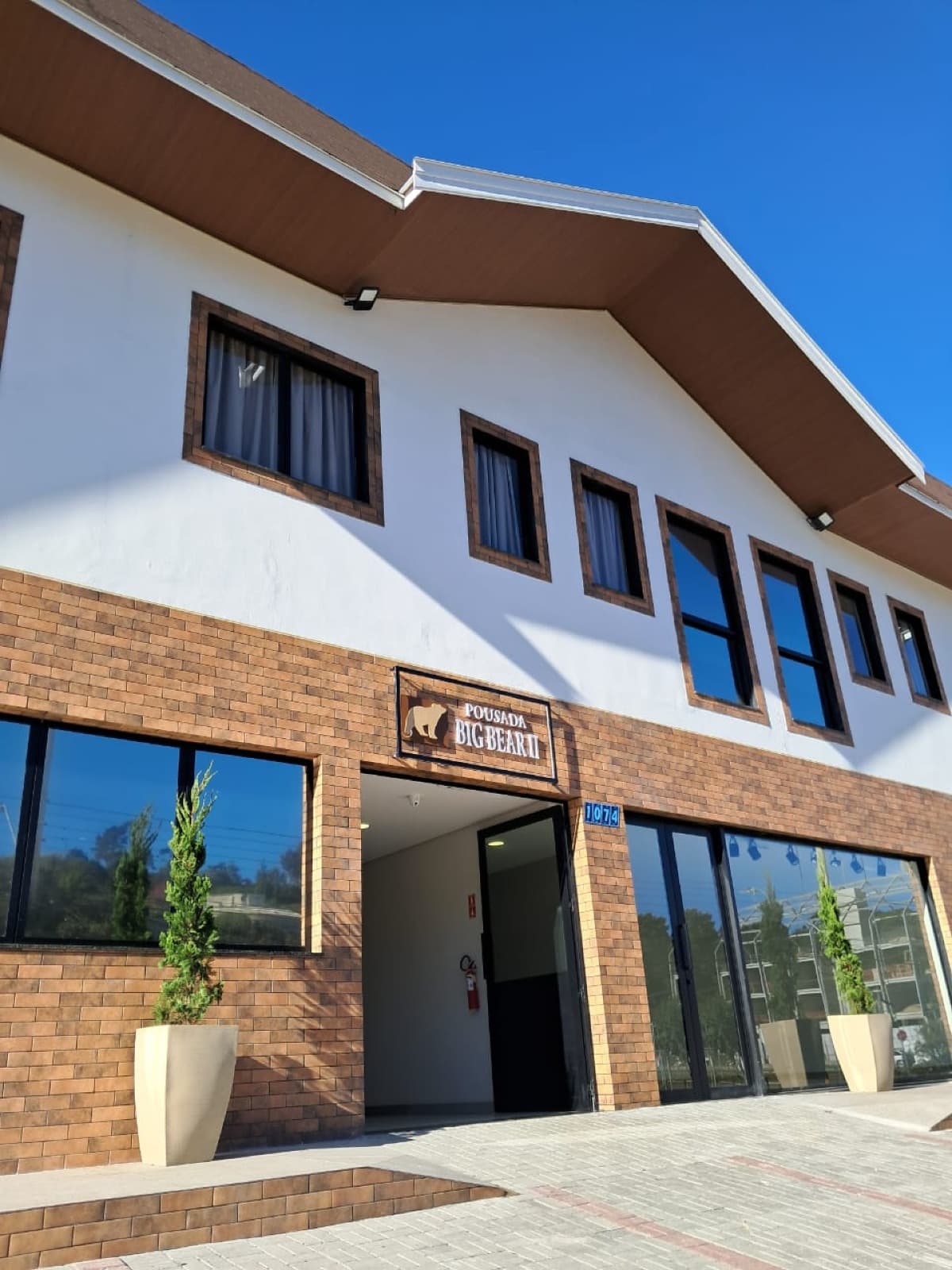 Fachada da Pousada Big Bear 2 sob céu azul, arquitetura contemporânea